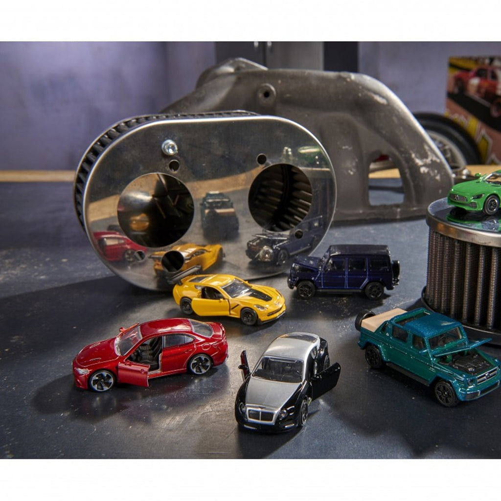 Varios autos Majorette Premium Cars metálicos con puertas abiertas en escena de taller