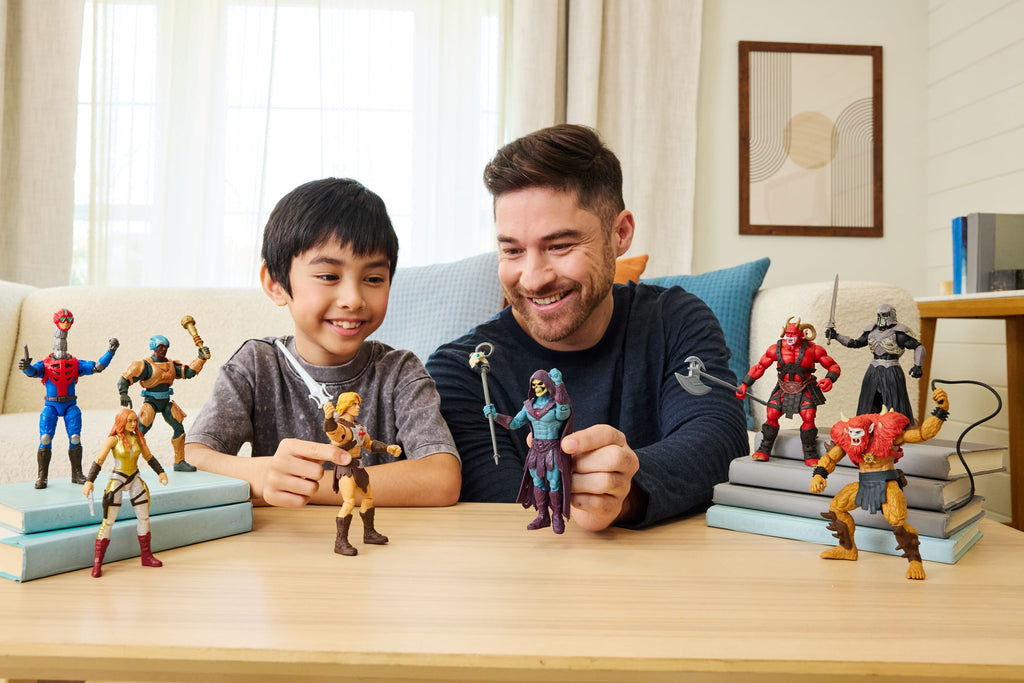 Niño y adulto jugando con figuras de Masters of the Universe