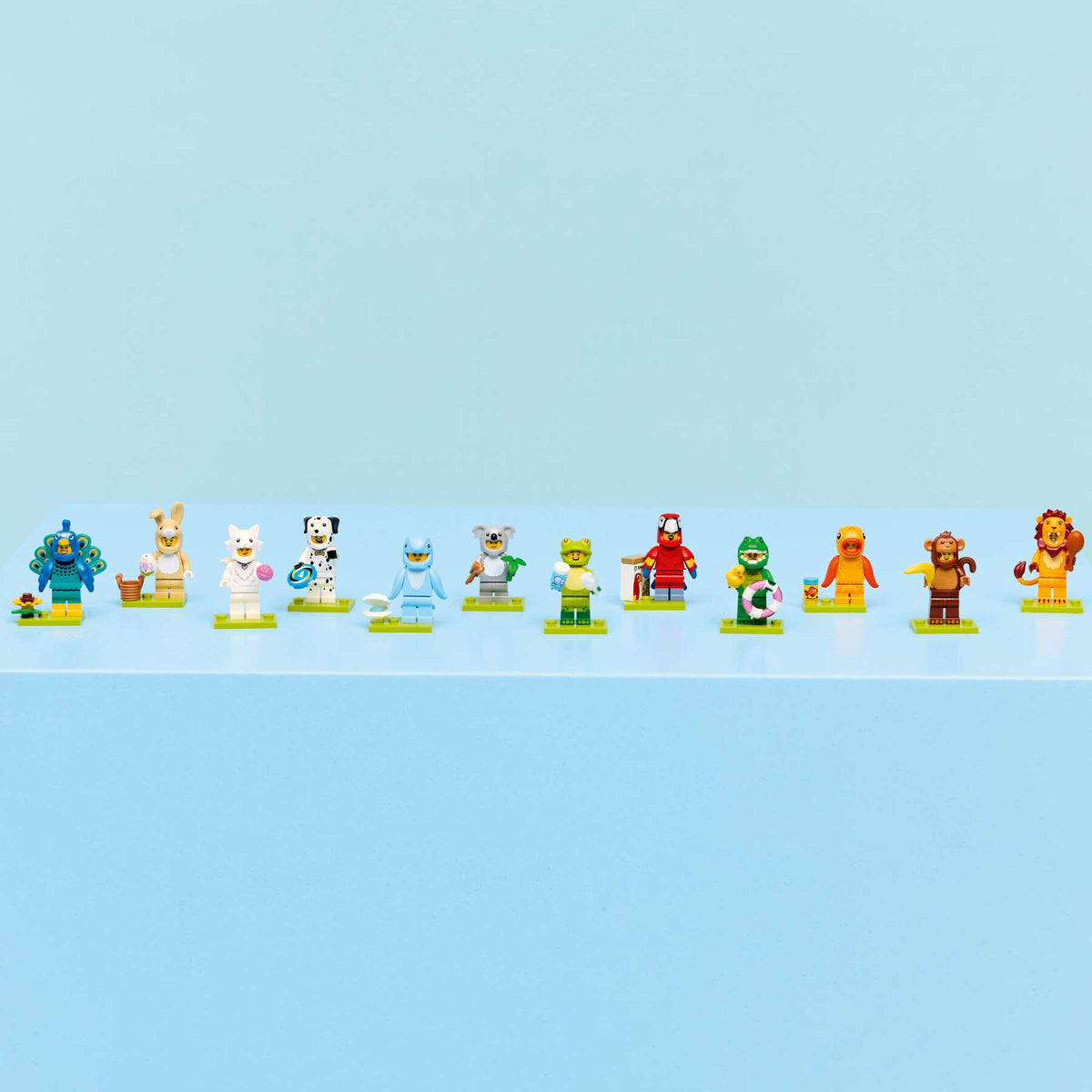 Fila con las 12 minifiguras LEGO Animales Serie 28 sobre sus bases