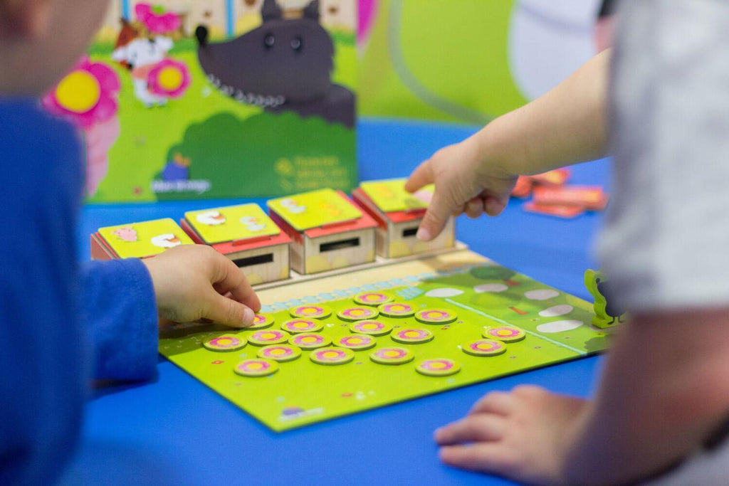 Niños jugando Mr. Wolf poniendo fichas de animales en el tablero