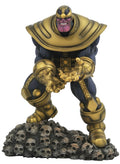 Estatua de Thanos con armadura dorada de pie sobre una base de calaveras