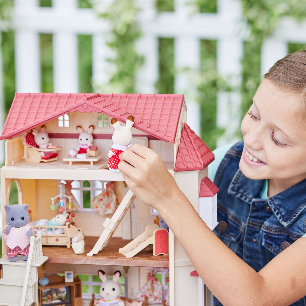 Niño jugando con la casa con ático secreto de Sylvanian Families