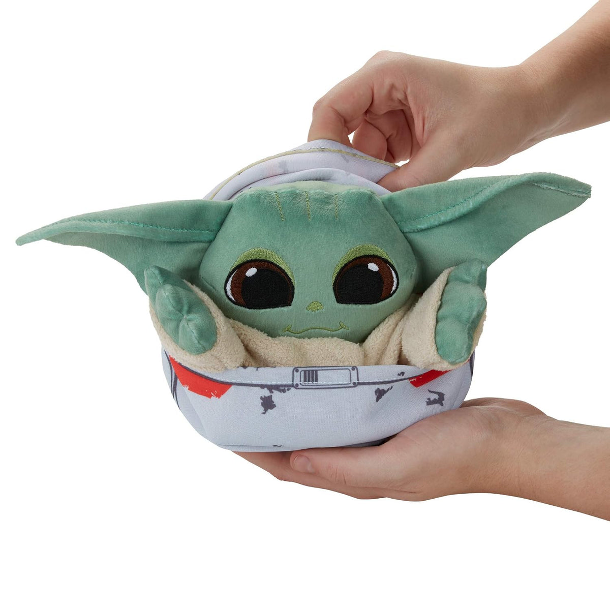 Grogu de peluche en el hover-pram sostenido en la mano