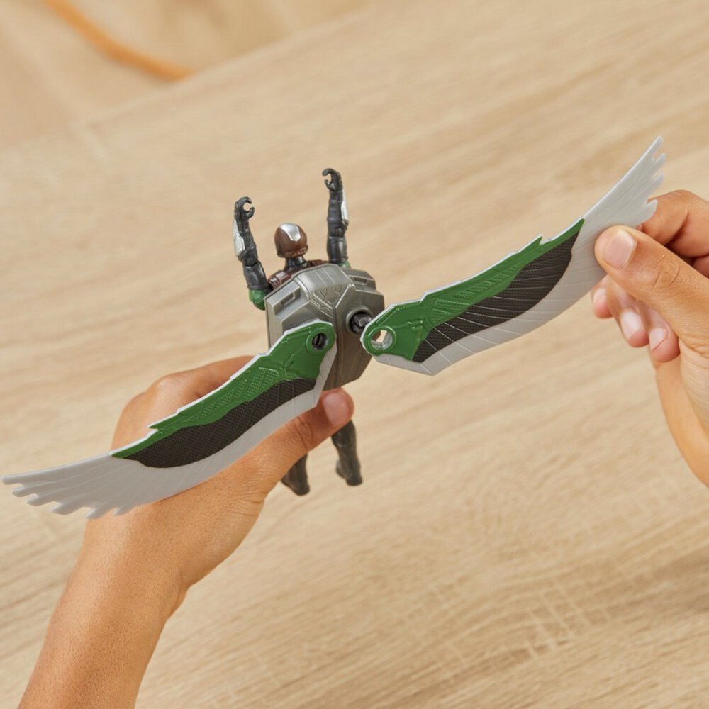 Niño abriendo las alas de la figura de Falcon sobre una mesa de madera