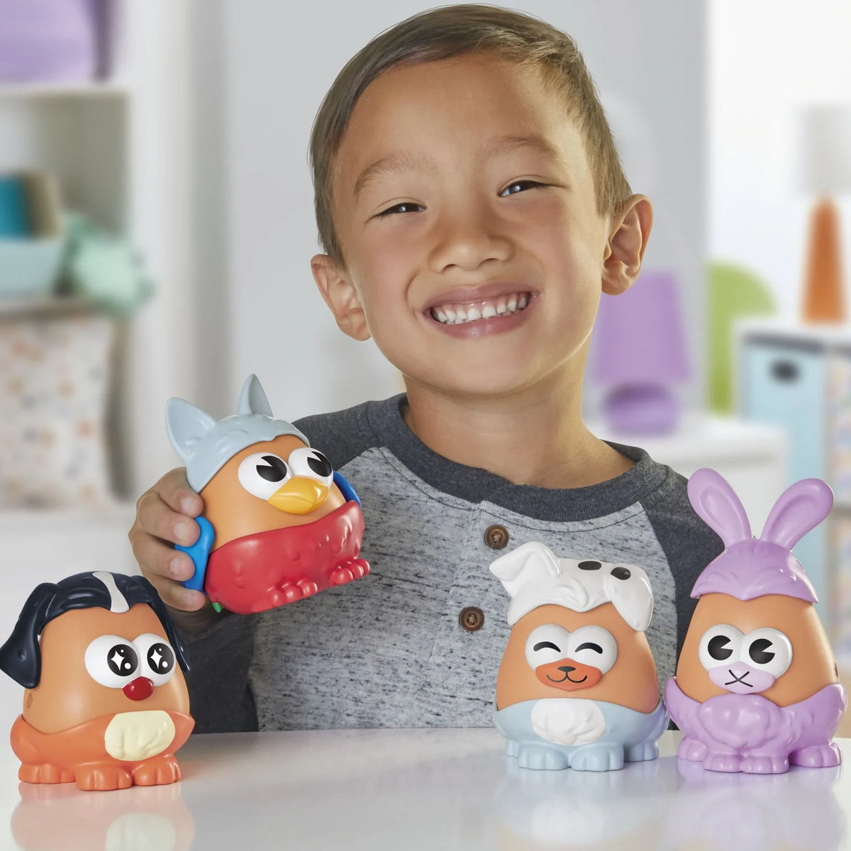 Niño jugando con las figuras Potato Head mascotas sobre una mesa