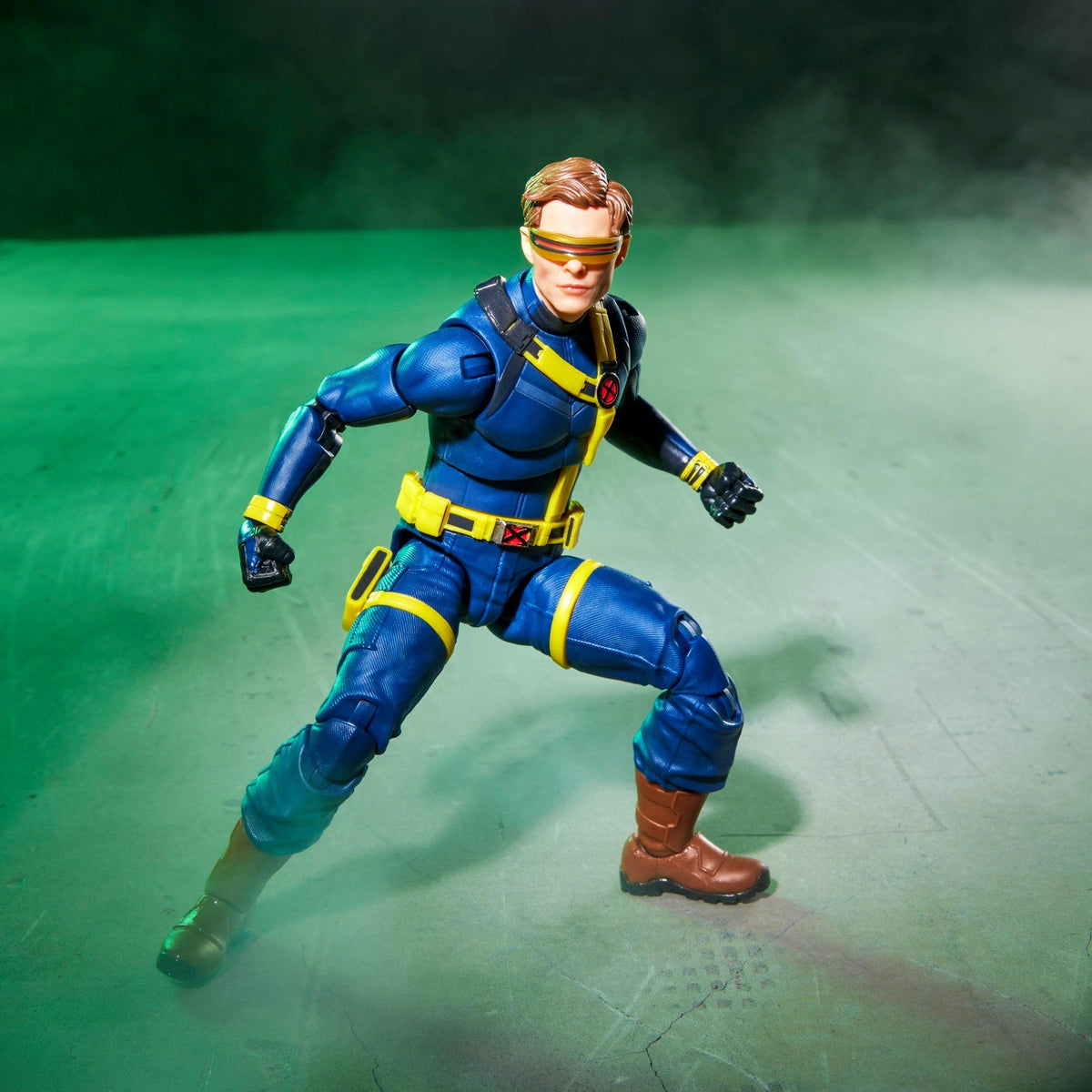 Figura Cyclops Marvel Legends en pose de combate sobre fondo verde
