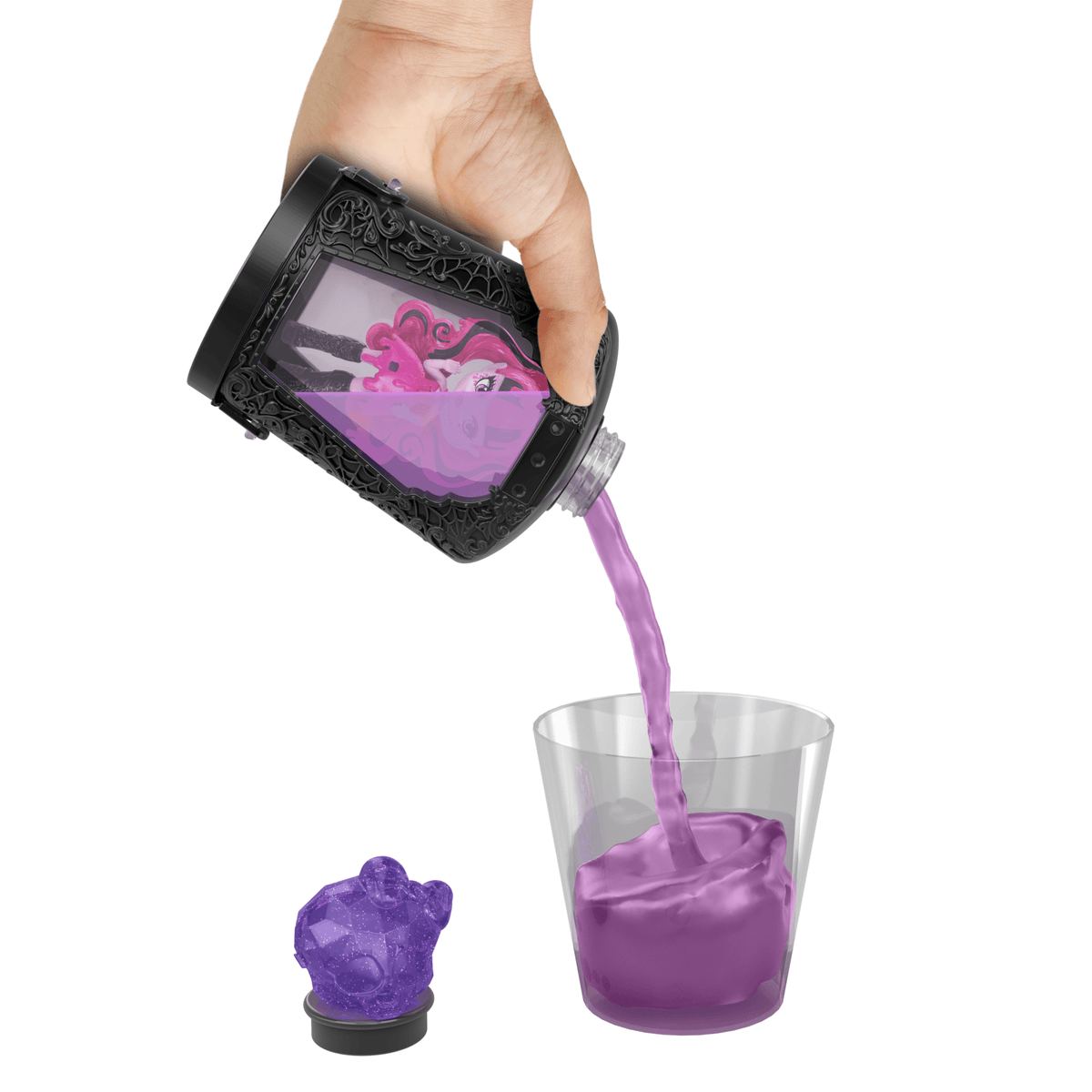 Mano vertiendo la poción morada para revelar la mini muñeca Monster High
