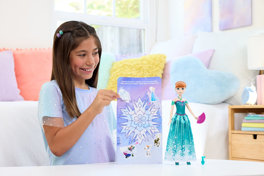 Niña decorando el escenario de Frozen con calcomanías junto a la muñeca Anna