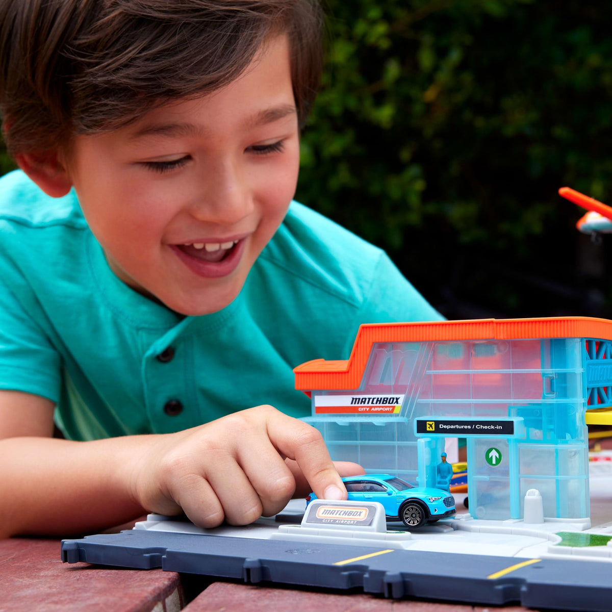 Niño jugando con el terminal del aeropuerto Matchbox y el auto Audi e-tron