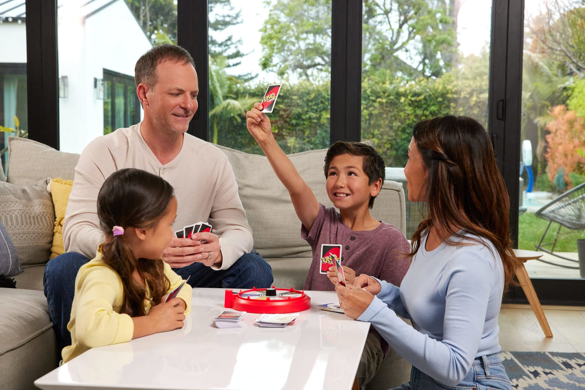 Familia jugando UNO Spin en el living con la ruleta sobre la mesa