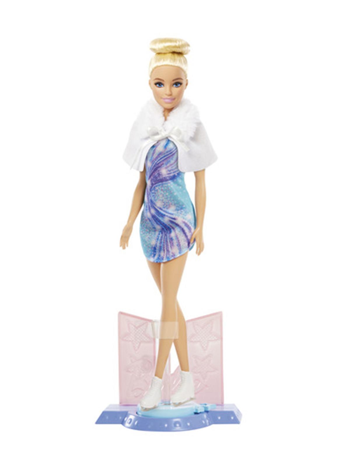 Barbie patinadora con vestido azul lila y chaqueta blanca sobre su base de pista