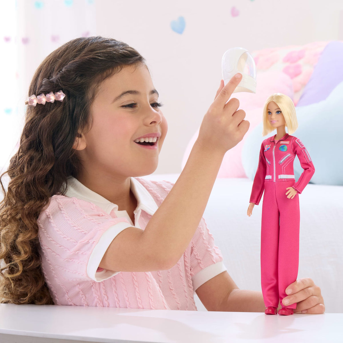 Niña jugando con la muñeca Barbie astronauta y su casco