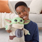 Niño abrazando el peluche Grogu de 28 cm