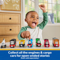 Niño celebrando junto a la colección de locomotoras de metal Thomas & Friends