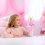 Niña jugando con la muñeca Barbie Clara en pose de ballet en una sala rosada