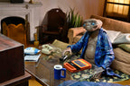 Figura NECA E.T. 40 aniversario sentada junto a una mesa con teléfono y Speak & Spell