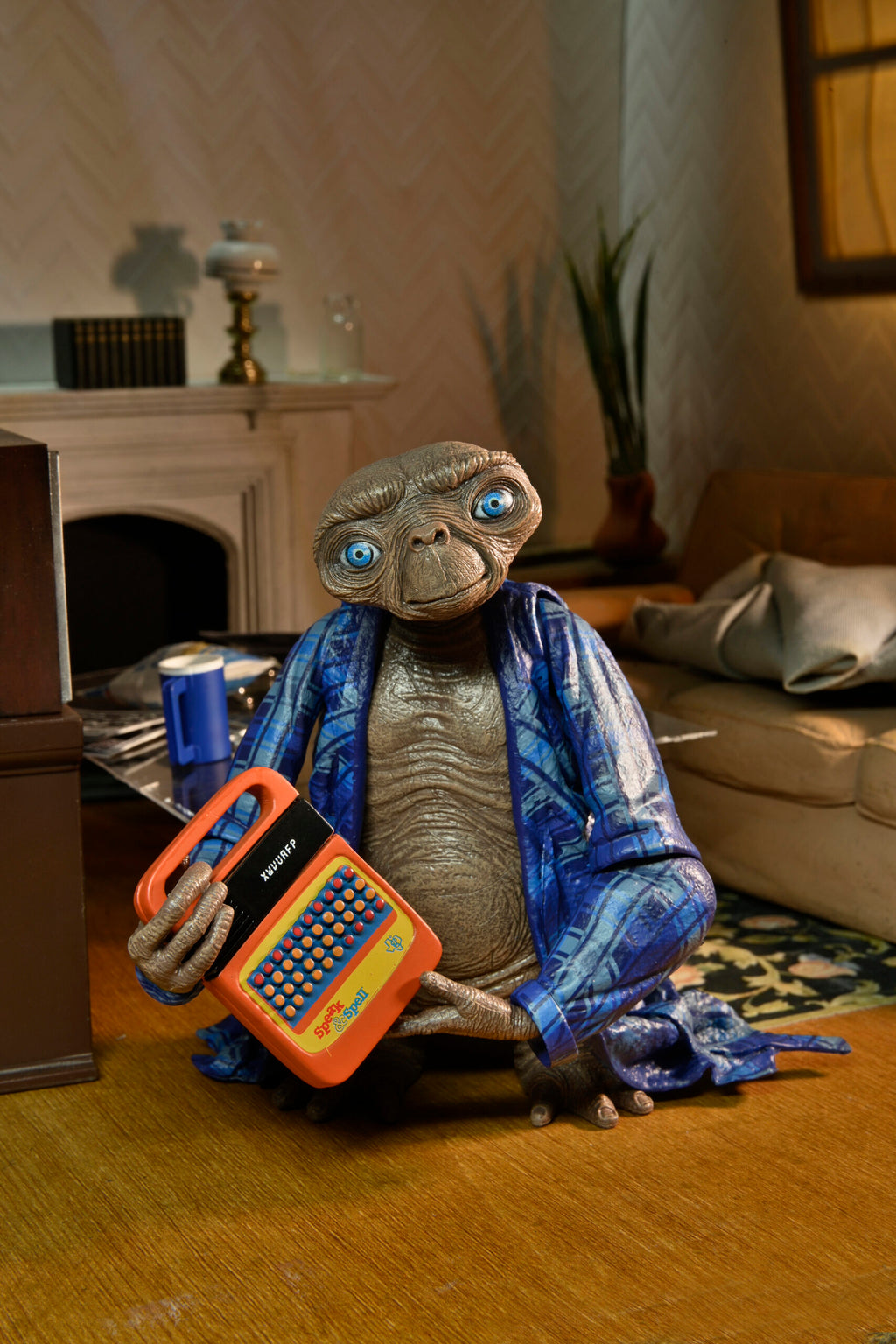 Figura Ultimate Telepathic E.T. de NECA sosteniendo el Speak & Spell naranja