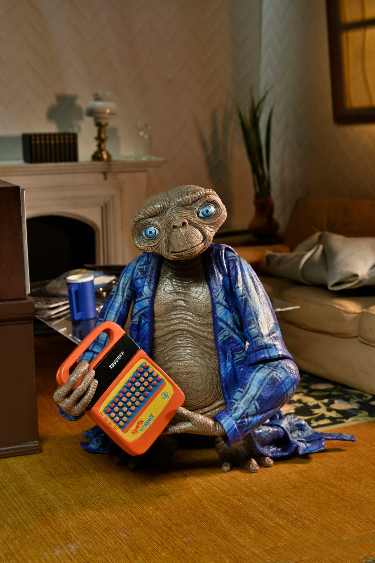 Figura Ultimate Telepathic E.T. de NECA sosteniendo el Speak & Spell naranja