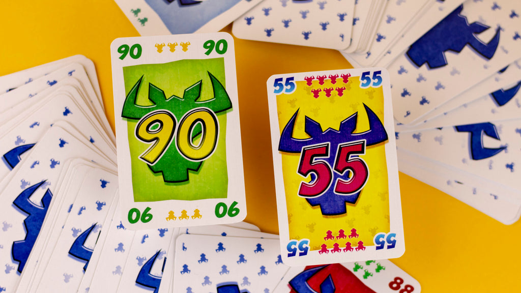 Cartas de ¡Toma 6! con los números 90 y 55 sobre fondo amarillo